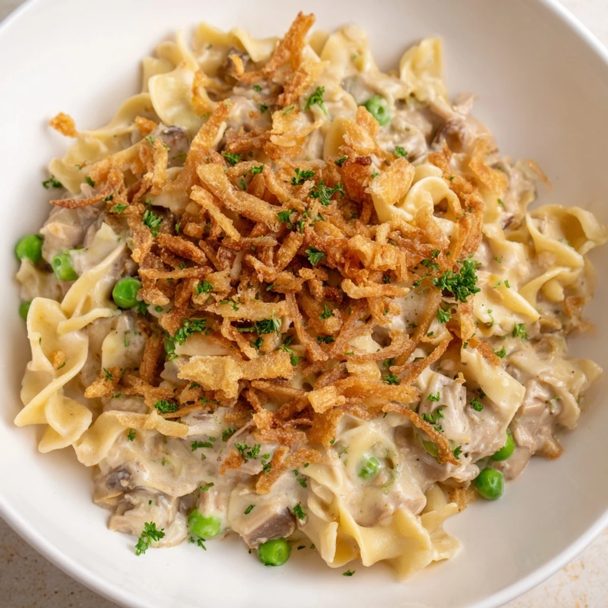 Golden, bubbly Tuna Noodle Casserole with a crispy onion topping, perfect for a cozy weeknight meal.