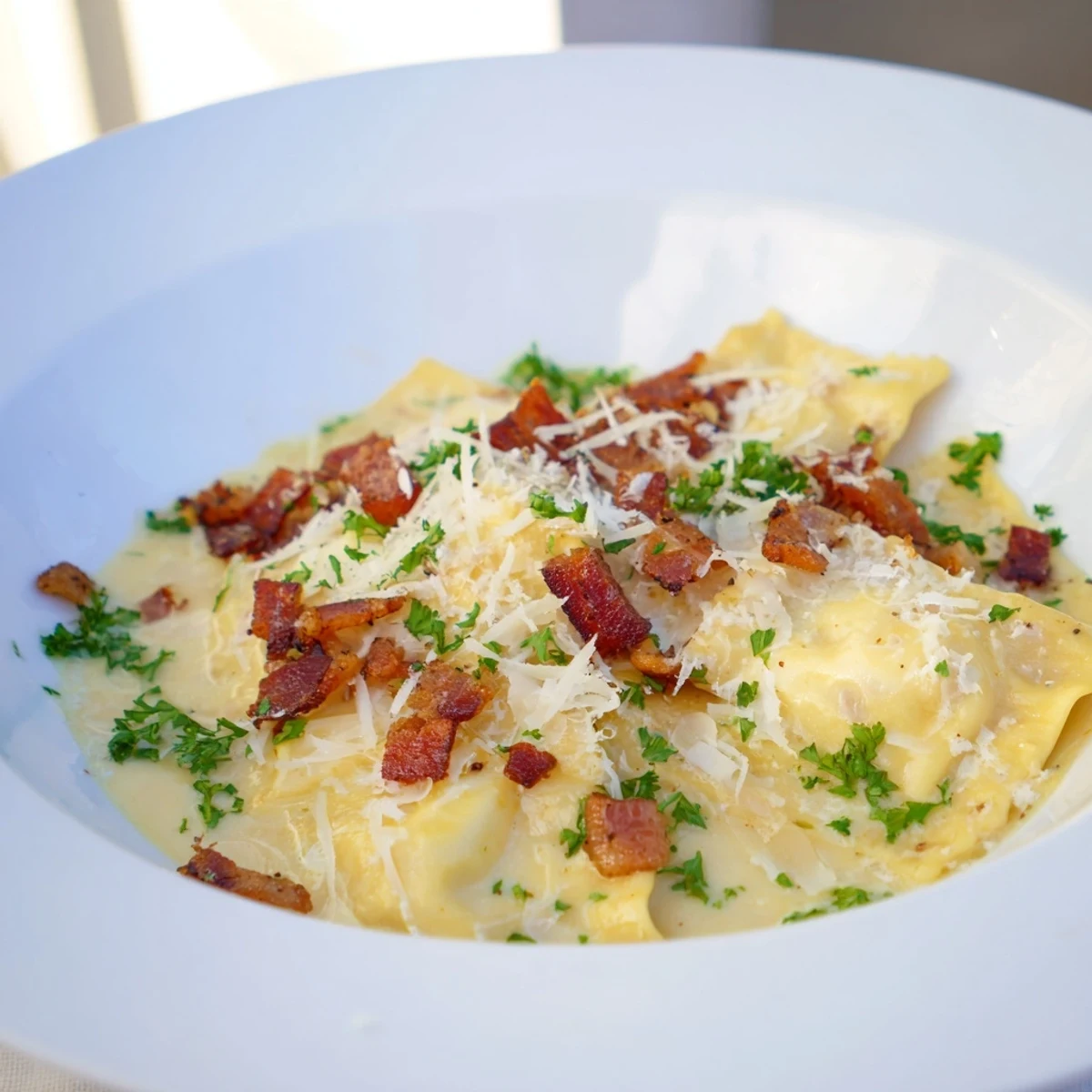 Golden-brown pancetta complements the rich sauce and tender cheese-filled Olive Garden Ravioli Carbonara in this photo.