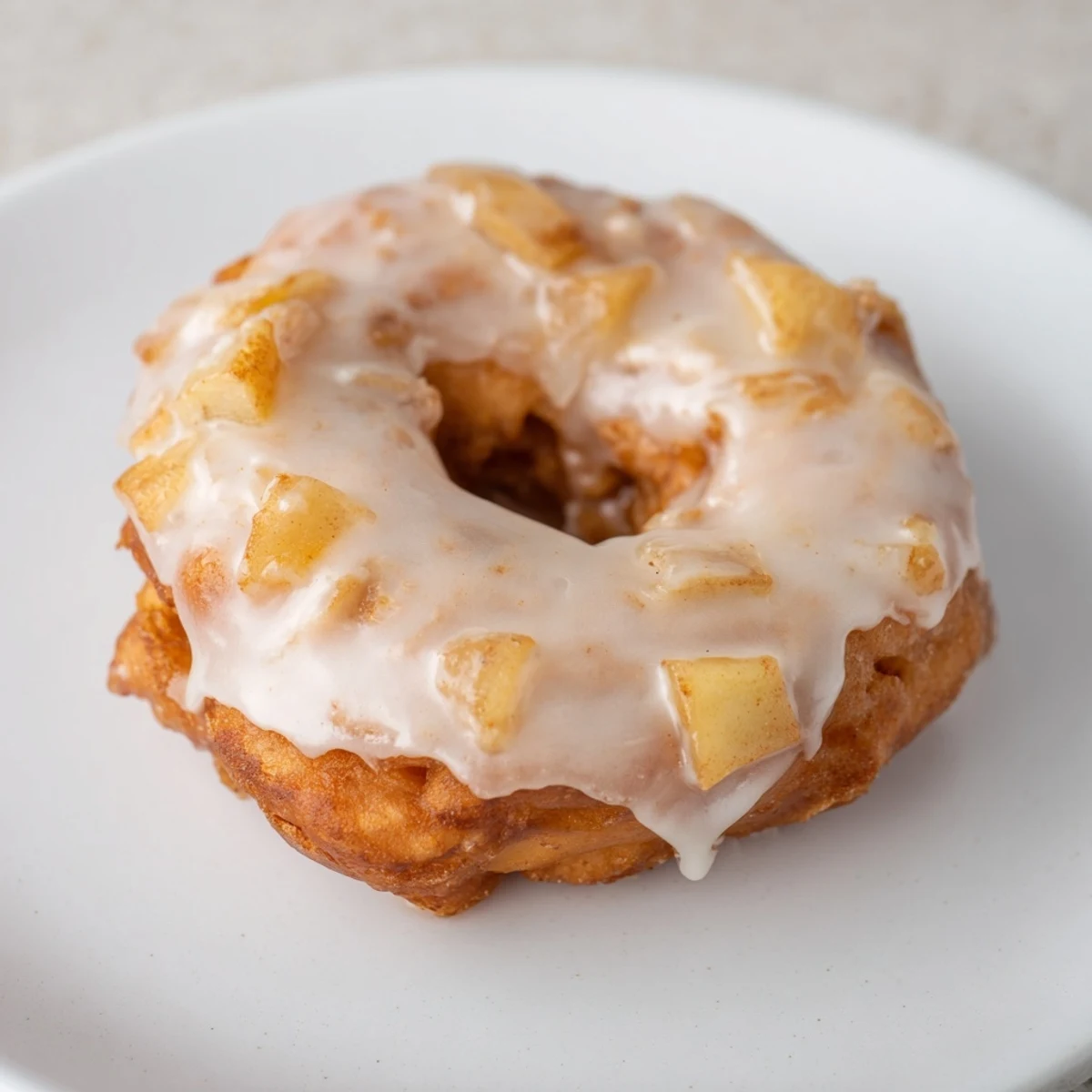 Golden, crispy homemade apple fritters, served warm and drizzled with a sweet, vanilla glaze.