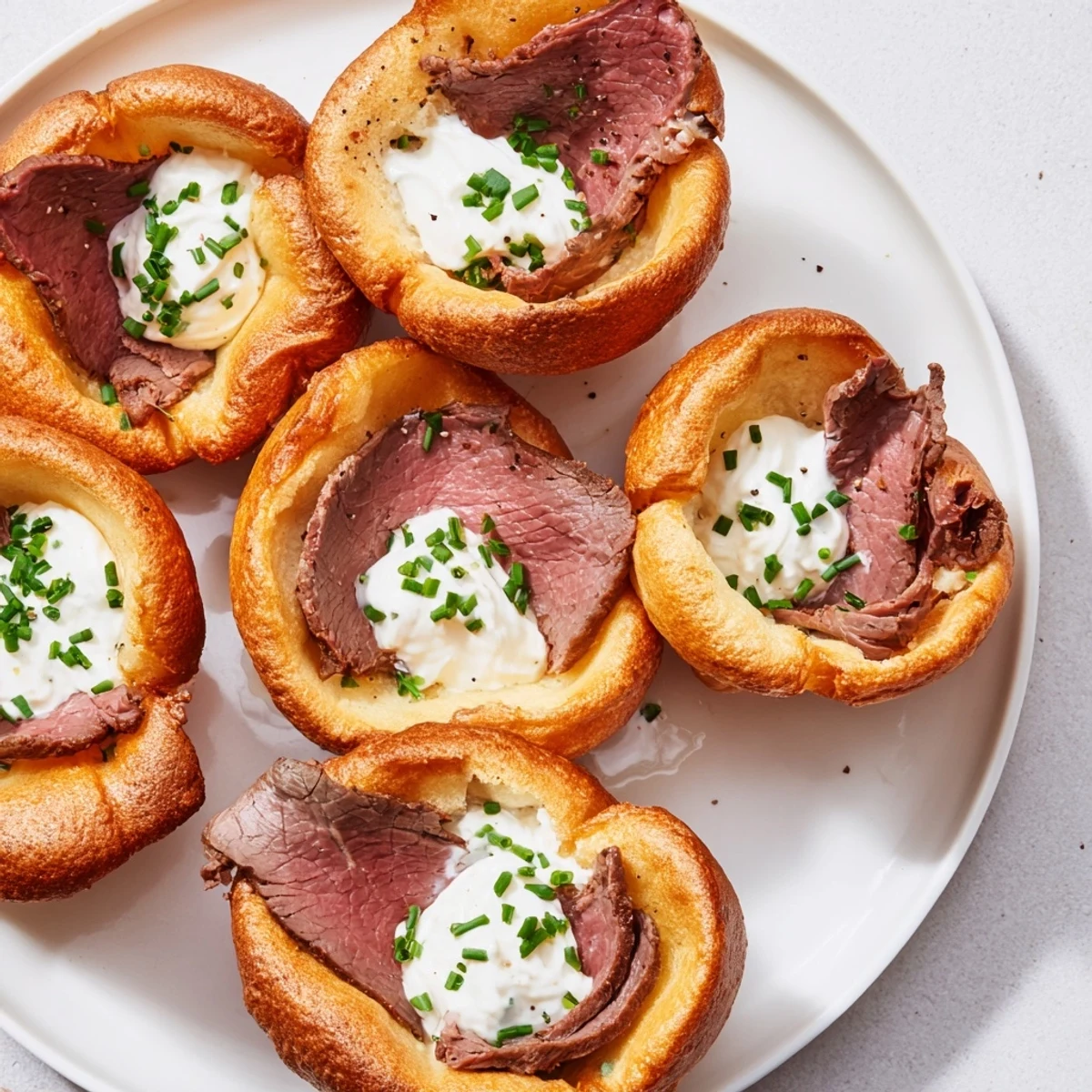 Golden brown Express Holiday Yorkshire Pudding Bites, filled with savory roast beef and tangy horseradish cream.