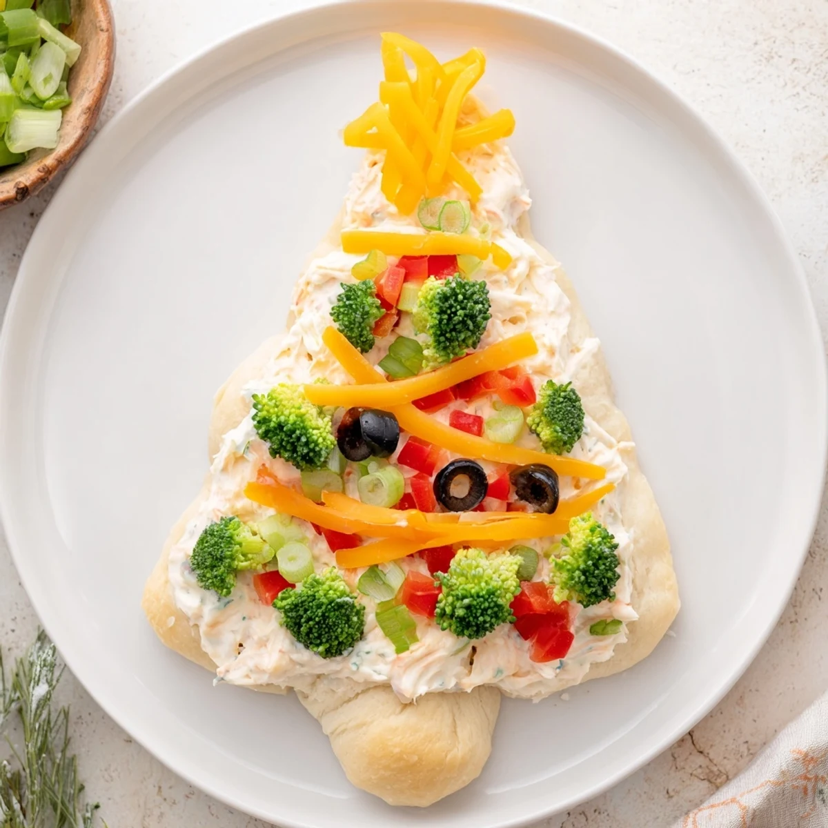 Close-up of a delicious Easy Christmas Tree Veggie Pizza, imagine the fresh flavors and creamy textures.