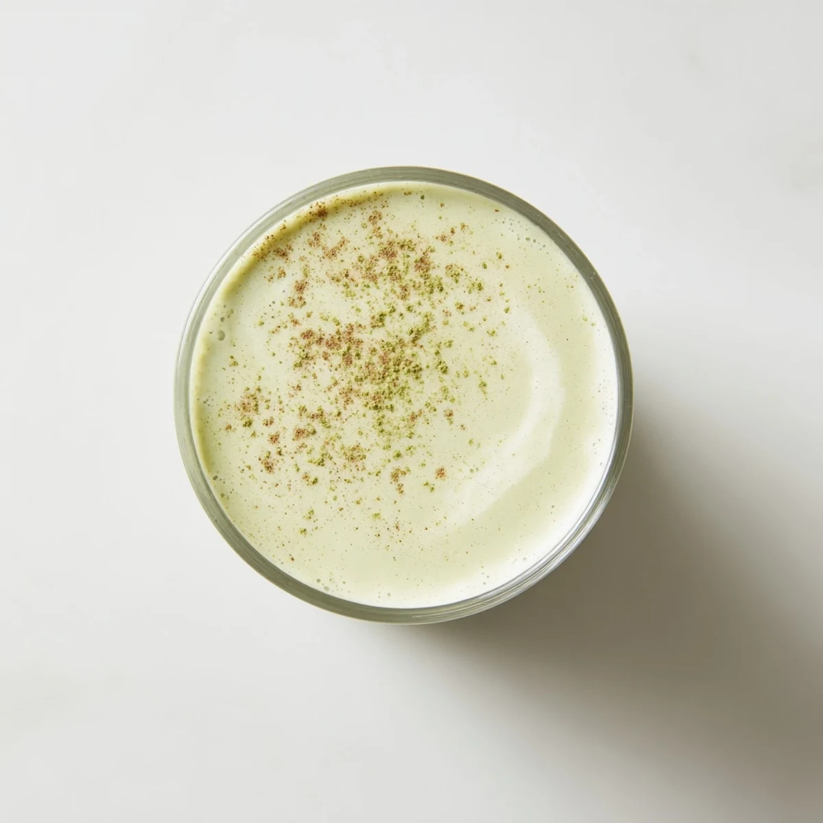 This Matcha Eggnog Collagen Breakfast Smoothie features a vibrant green color, blended with fresh banana, ready to enjoy.