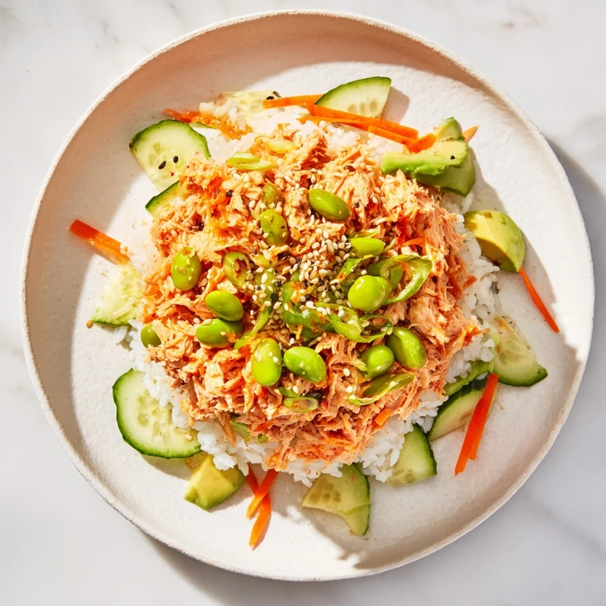 Steaming Spicy Canned Salmon Rice Bowl piled high with colorful vegetables and creamy sriracha mayo.