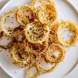 Air-fried crispy onion cheese chips featuring perfectly browned cheese and onion rings; a savory treat.