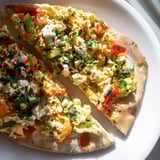 A close-up of a flavorful Turkish Menemen Eggs Pizza, with bubbling eggs and crispy crust, perfect for brunch.