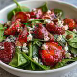 Fresh baby spinach and ripe strawberries tossed with creamy feta and crunchy almonds, drizzled with tangy poppy seed dressing.  