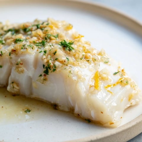 Tender garlic butter baked cod with herbs, drizzled in a rich sauce.  
