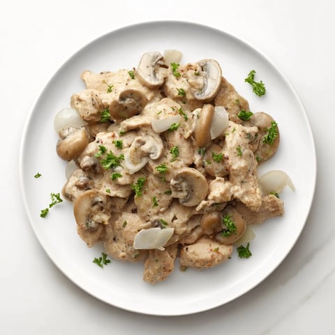 Creamy Chicken Stroganoff, a steaming bowl of tender chicken and earthy mushrooms in a rich sauce.