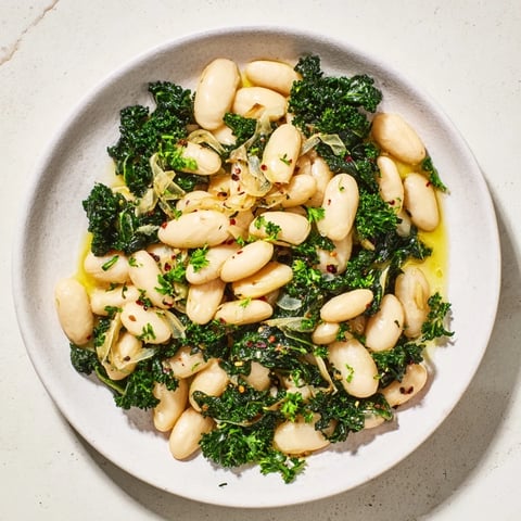 Steaming Garlicky Beans with Winter Greens, vibrant green hues and creamy beans are ready to serve.