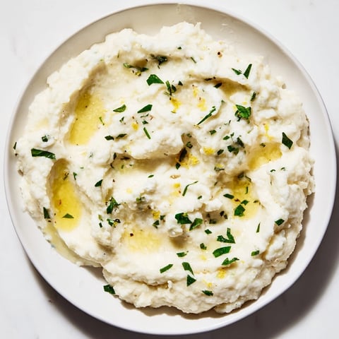 Creamy cauliflower mash with roasted garlic and herbs, a healthy, flavorful side dish.
