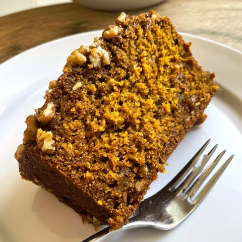 Warm, spiced pumpkin bread loaf, perfectly golden, ready to slice and enjoy with coffee.