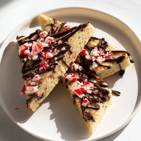Delectable Chocolate Peppermint Shortbread Wedges, drizzled with chocolate and sprinkled with crushed peppermint.