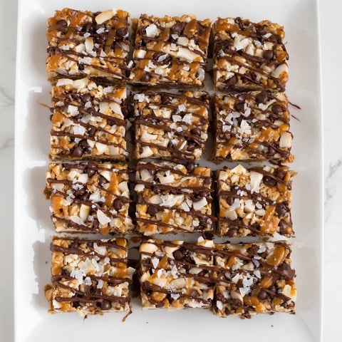Seven-layer magic bars with caramel drizzle show a rich dessert, perfect for sharing and easy to make.