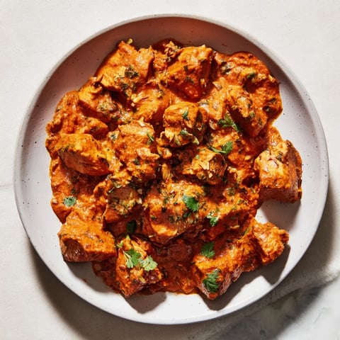 A vibrant bowl of Instant Pot Chicken Tikka Masala, swimming in a rich, creamy coconut sauce.