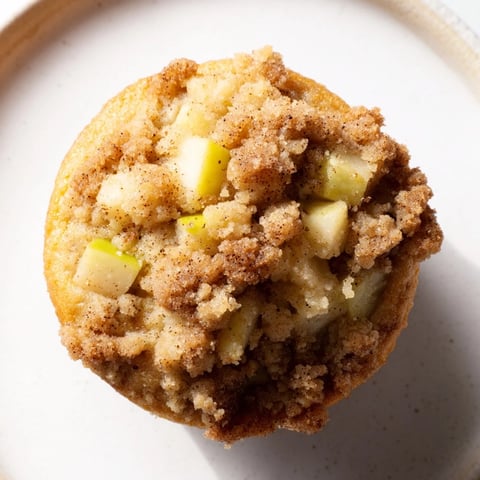 Golden-brown Tasty Apple Muffins, fresh from the oven, topped with a buttery, crispy crumb.