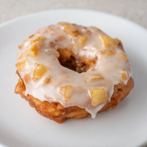 Golden, crispy homemade apple fritters, served warm and drizzled with a sweet, vanilla glaze.