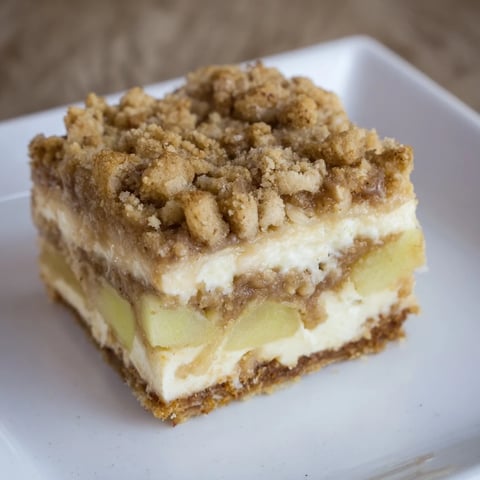 Golden-brown Apple Crisp Cheesecake Bars show off a delicious combination of textures and flavors.
