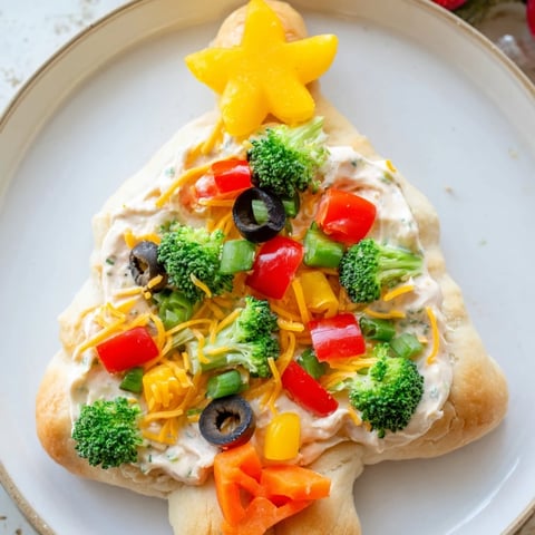 Easy Christmas Tree Veggie Pizza arranged on a platter, showcasing colorful veggies and vibrant cheese.