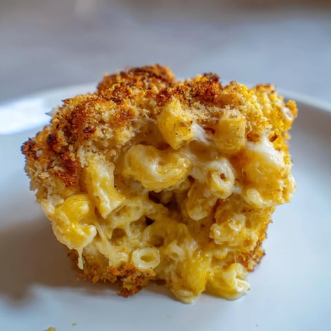 Golden-brown Ditalini Mac and Cheese Bites, each bite oozing a creamy cheese center, ready to eat.