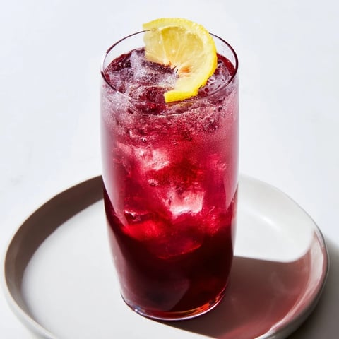 A chilled Sleepy Girl Mocktail: ruby-red tart cherry juice sparkles with effervescence, ready to sip.