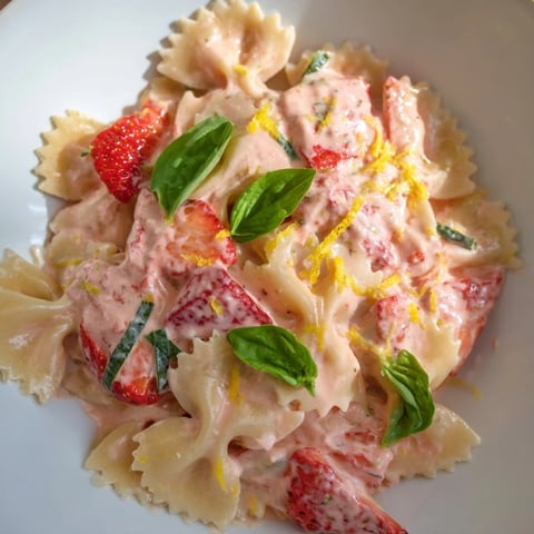 Creamy strawberry sour cream pasta, a vibrant dish with fresh basil garnish, ready to serve.