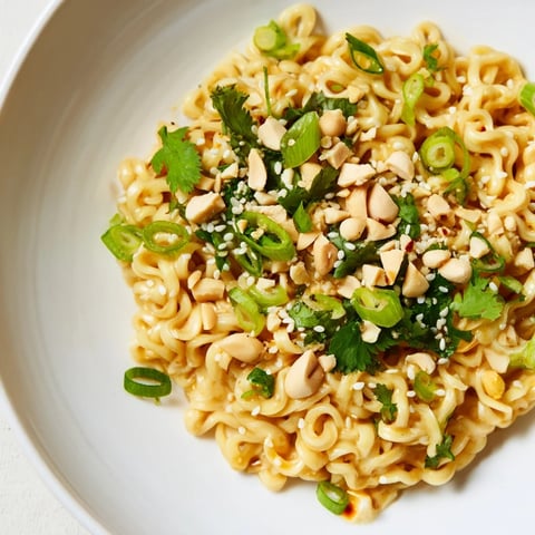 Steaming hot Instant Peanut Thai Sauce Noodles, coated in a rich, glossy peanut sauce, ready to eat.