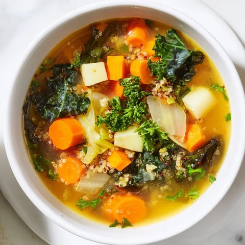 A steaming bowl of Nourishing Winter Veggie Soup, with colorful vegetables and fluffy quinoa.