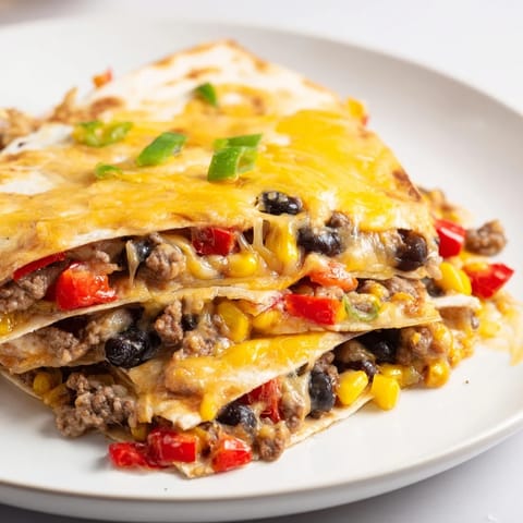Melted cheese bubbling over seasoned beef and tortillas in these savory sheet pan quesadillas.