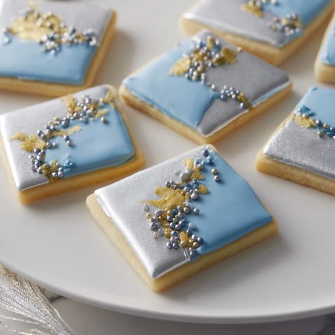 An Engagement Ring Diamond Dessert Tray features a stunning array of iced cookies with edible gems and colorful berries.