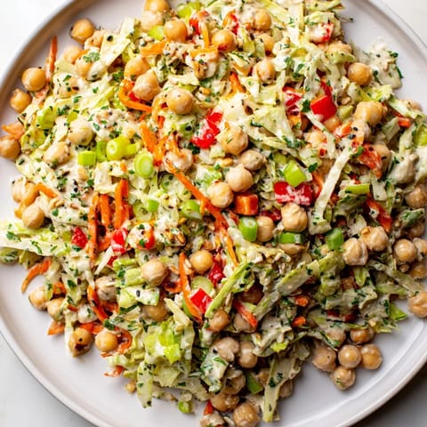Freshly tossed fiber-forward chickpea salad, full of vibrant colors and delicious Mediterranean flavors.