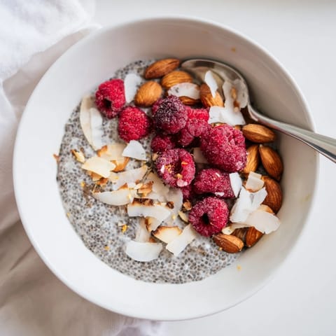 A healthy breakfast jar of Poppy Seed Chia Pudding with berries and shredded coconut.