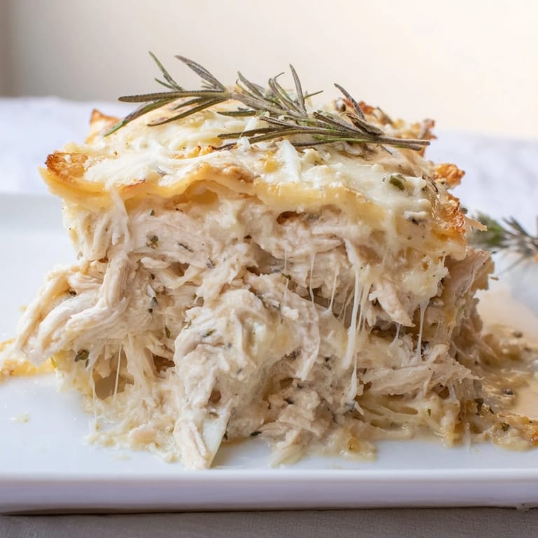 Golden-brown top of a Rosemary Chicken Lasagna, showcasing melted mozzarella and Parmesan cheese textures.
