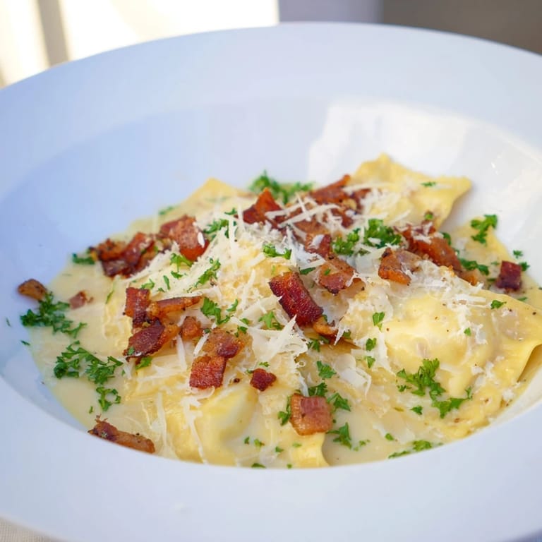 Golden-brown pancetta complements the rich sauce and tender cheese-filled Olive Garden Ravioli Carbonara in this photo.
