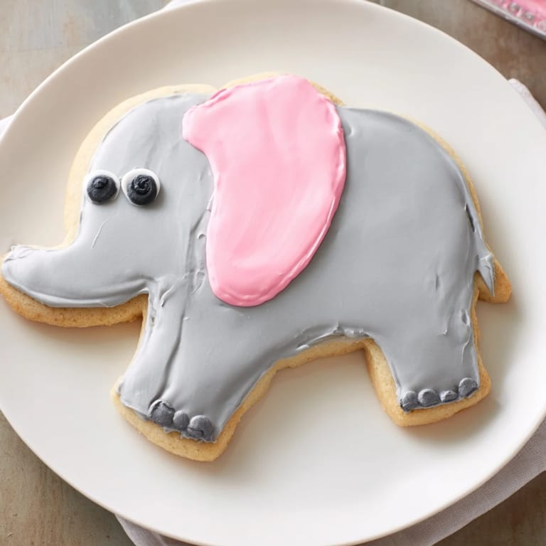 Freshly baked Biscuits Amical Éléphant Géant cookies, featuring gray icing and adorable pink ears, waiting to be served.