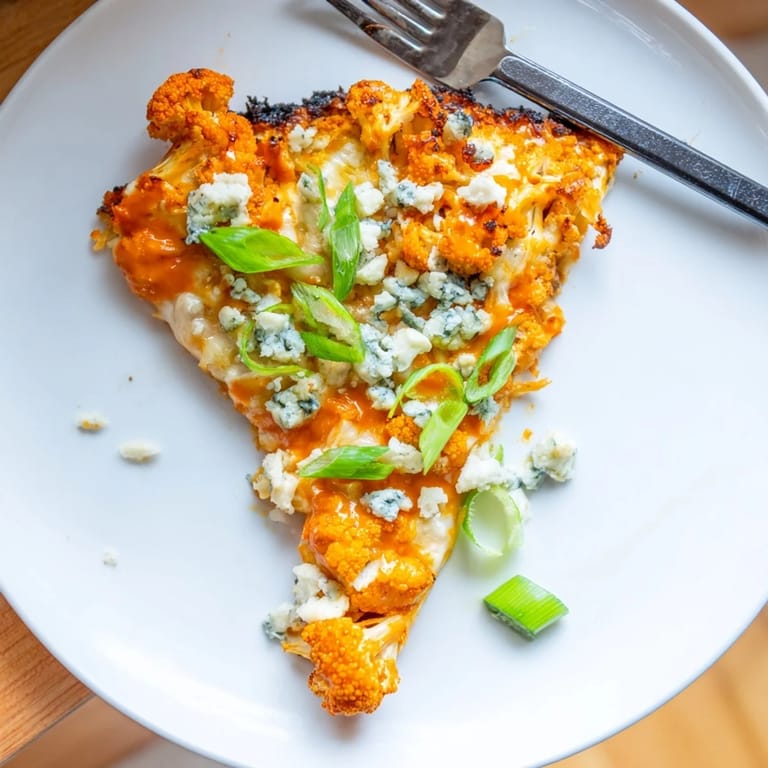 Freshly baked Buffalo Cauliflower Pizza topped with sliced green onions and a hint of spicy buffalo sauce.  