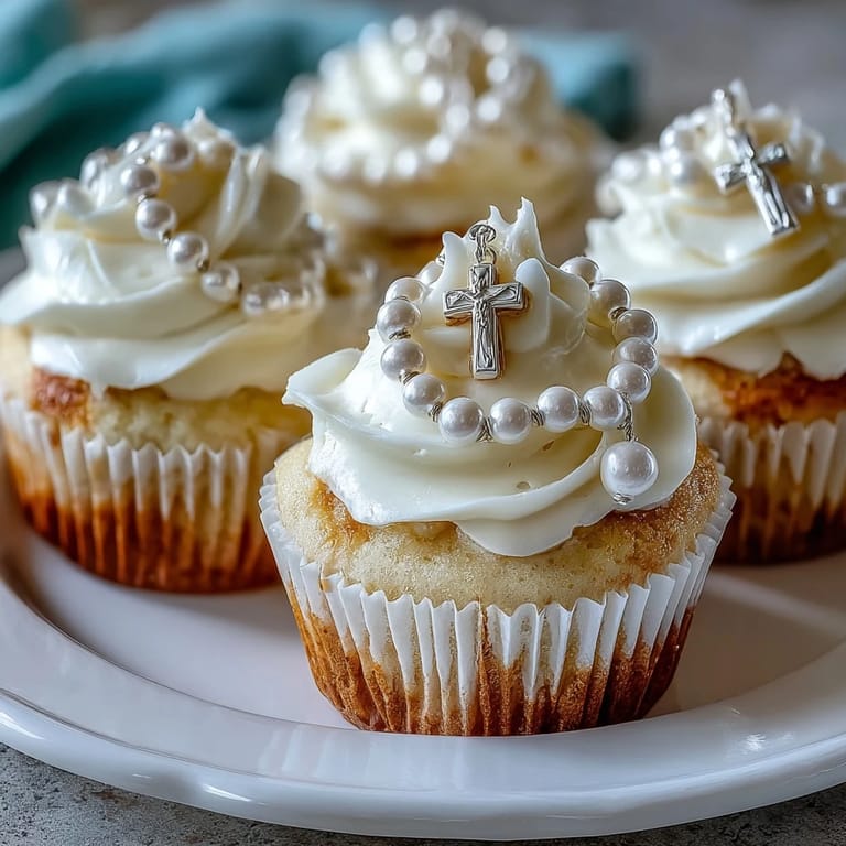 Adorable mini cupcakes with creamy frosting and edible fondant rosary decorations, perfect for religious milestone parties.